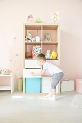 boy in the hands sat on the floor near the wardrobe