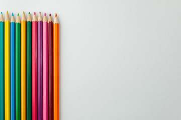 set of colored pencils on white background, place for text