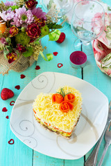 Salad with meat, mushrooms, cheese and vegetables on the festive table on Valentine's Day.