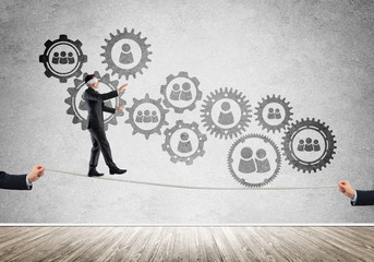 Business concept of risk support and assistance with man balancing on rope