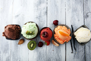 Set of ice cream scoops of different colors and flavours with berries, nuts and fruits