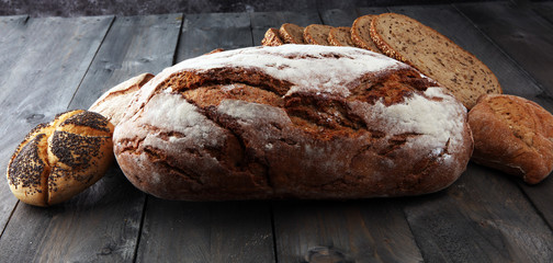Different kinds of bread and bread rolls on wooden table. Kitchen or bakery poster design