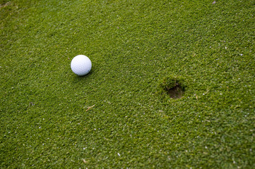 Golf ball on green with ball mark