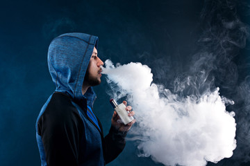 vaping man holding a mod. A cloud of vapor.