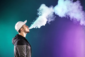 vaping man holding a mod. A cloud of vapor.