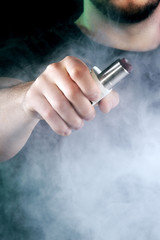 vaping man holding a mod. A cloud of vapor.