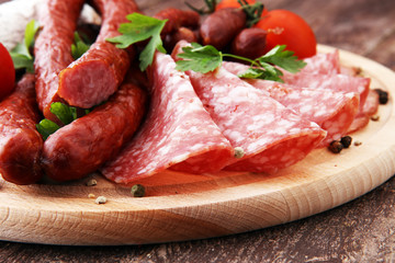 Food tray with delicious salami, pieces of sliced ham, sausage, tomatoes, salad and vegetable - Meat platter with selection - Cutting sausage and cured meat