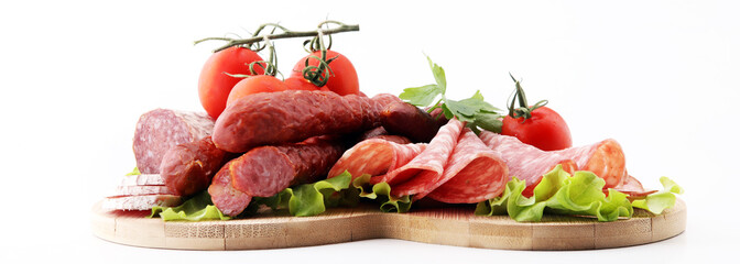 Food tray with delicious salami, pieces of sliced ham, sausage, tomatoes, salad and vegetable -...