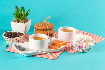 Cake, cups with coffee, cookies on a bright background