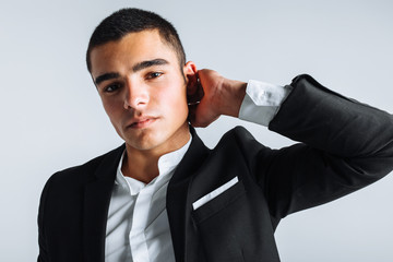 handsome young man in a stylish suit, posing on a white background isolated