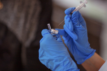 Women's hands hold the syringe with needle