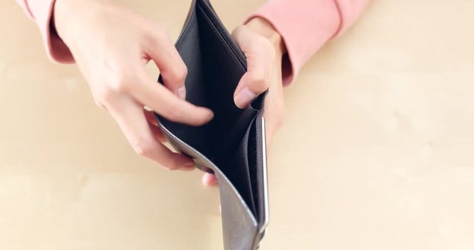 Woman opening empty wallet