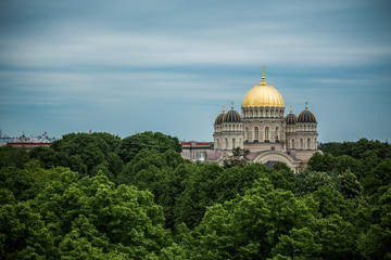 Fototapeta na wymiar Orthodox Cathedral golden dome above Riga city trees.