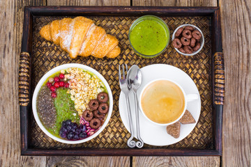 Wooden tray with fruit dishes and croissant for lunch