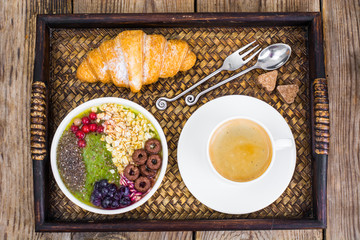 Wooden tray with fruit dishes and croissant for lunch