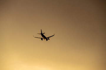 Airplane take off silhouette with sunlight in background.
