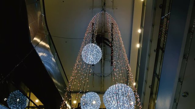 Industrial climber mounts Christmas decorations in the unsupported space in the shopping center