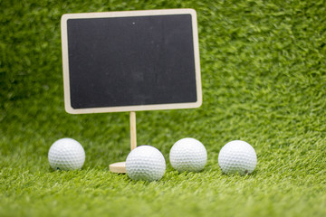 Golf school training concept with chalkboard and golf balls on green grass