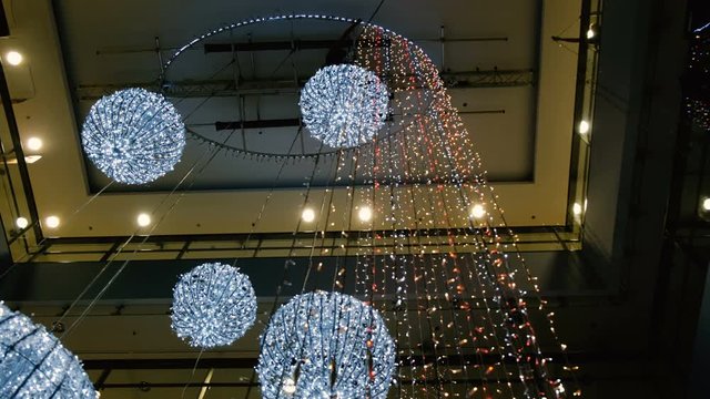 Industrial climber mounts Christmas decorations in the unsupported space in the shopping center