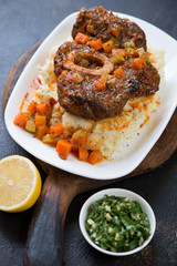 Plate with ossobuco served on mashed potato, selective focus, vertical shot