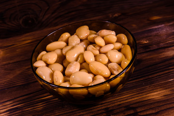 White marinated haricot beans in glass bowl on a wooden table