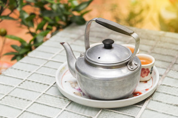 Obraz na płótnie Canvas Tea pot in afternoon garden with soft sunlight.