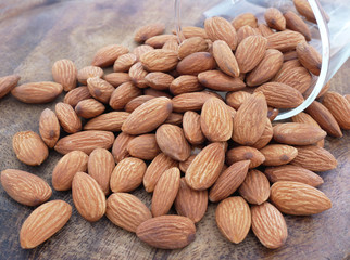 Almonds in glass on grunge wooden background. Healthy food.