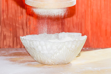 Flour during sifting into a glass bowl