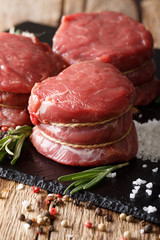Fresh raw filet mignon steak with ingredients macro on the table. vertical