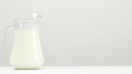 Glass jar full of milk on white background. Organic dairy. Natural healthy drink. Free space concept