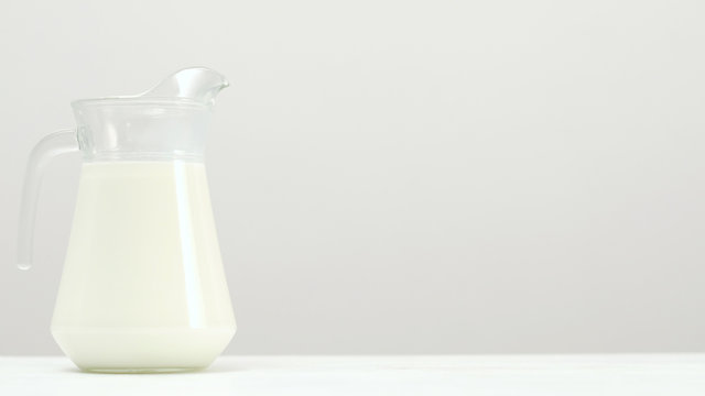 Glass jar full of milk on white background. Organic dairy. Natural healthy drink. Free space concept