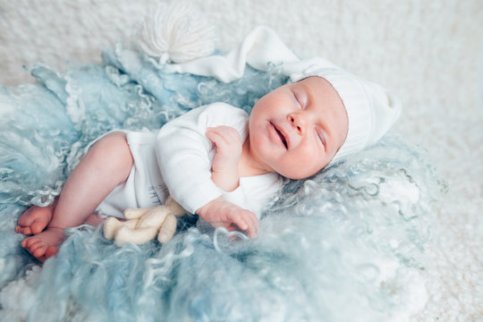 newborn baby in white clothes sleeping in a light blue woolen blanket. full length. the concept of childhood.