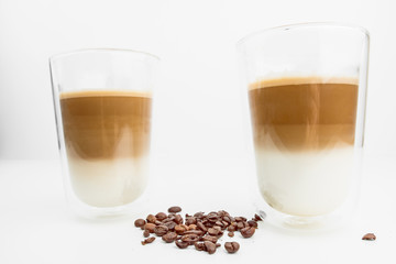 Two Hot Coffee Drinks With Milk With Coffee Beans On White Background