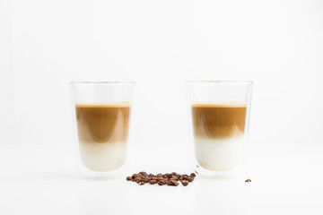 Two Hot Coffee Drinks With Milk With Coffee Beans On White Background