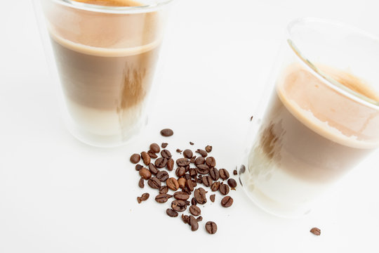 Two Hot Coffee Drinks With Milk With Coffee Beans On White Background