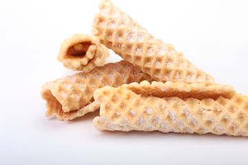 Homemade wafer rolls with powdered sugar isolated on white background