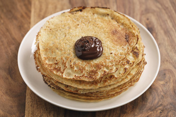 stack of crepes with dark chocolate poured on top