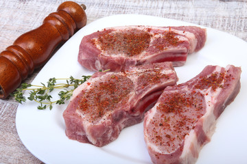 Raw pork chops and spice grinder on cutting board. Ready for cooking.