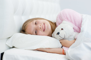 Teen girl on the bed with toy bear