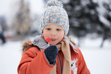 boy in a knitted winter hat with candy candy.