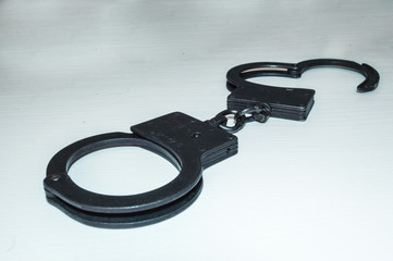 Metal police handcuffs on a white background. You are under arrest