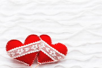 White fabric background with ruche.Two felt hearts with laces, symbol of love. Good for Valentine's...