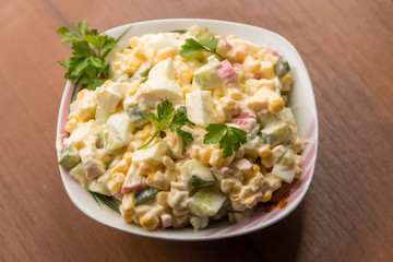 Salad with crab sticks, sweet corn, cucumber, eggs and mayonnaise