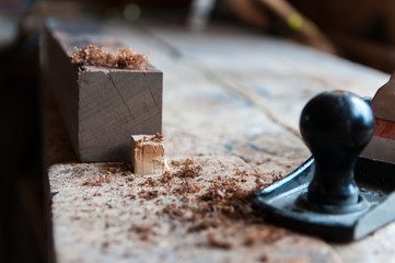 Wood chip in focus after planing a wood board in the small workshop.