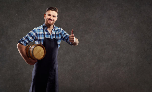 A brewer with a barrel in his hand against the background of copyspase.