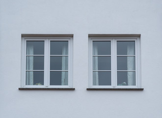 Weiße Fenster eines Hauses mit weißer Fassade