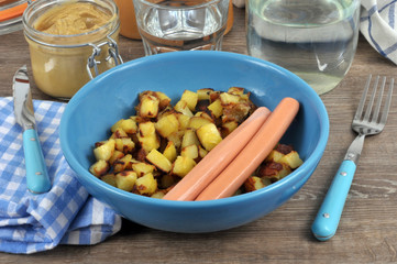 Pommes de terre rissolées et saucisses de Strasbourg dans une assiette 