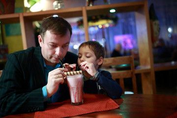 Father with son drinking milkshake