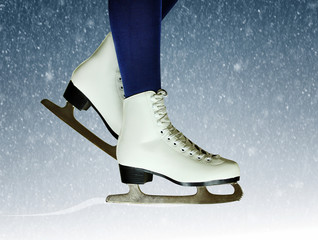 Female figure skates close-up on a snowy New Year's background. Winter skating background