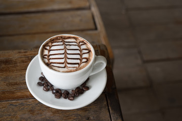 White coffee mug on patterned old wooden floor.